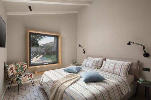 Un dormitorio con una cama con almohadas azules y una ventana. en Bino Marija, en Kirmenjak