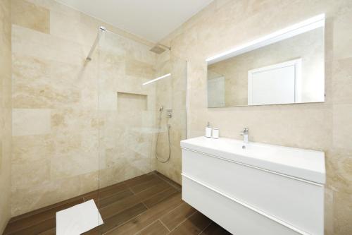 ein Badezimmer mit einem weißen Waschbecken und einem Spiegel in der Unterkunft Complex Homes4you in Kraj