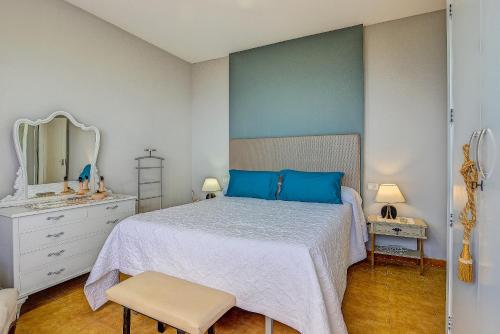 MazoにあるLightbooking La Carajita Villa de Mazoのベッドルーム(青い枕と鏡付きのベッド1台付)