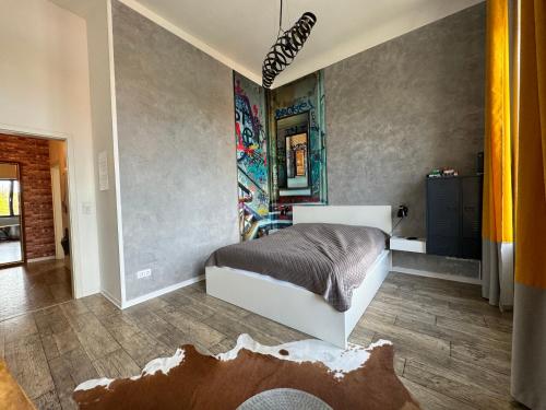 ゲルリッツにあるDESIGN Apartment I - 35qm Grenze Altstadt Parkのベッドルーム1室(ベッド1台付)が備わります。壁には絵画が飾られています。
