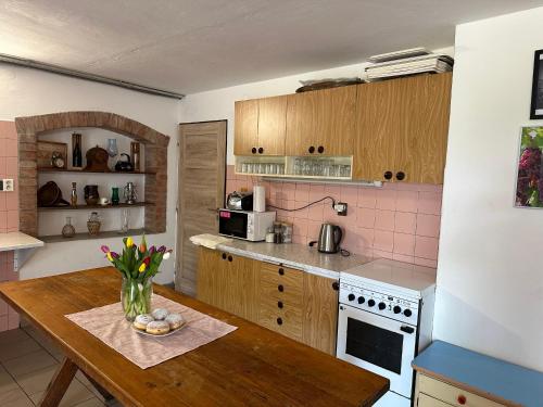 a kitchen with a wooden table with a vase of flowers at Vinný sklep v Zarazicích in Veselí nad Moravou