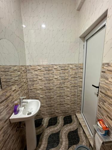 uma casa de banho com um lavatório e um chuveiro em Best Apartment em Adentan