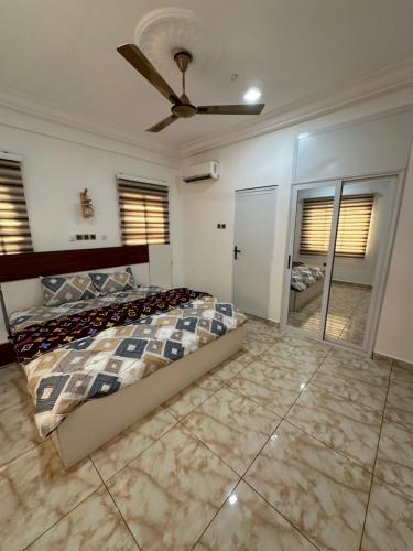 um quarto com uma cama e uma ventoinha de tecto em Best Apartment em Adentan