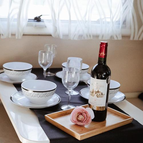 - une bouteille de vin sur une table avec des assiettes et des verres dans l'établissement the green paradise, à Celles