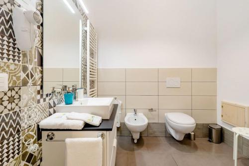 a white bathroom with a sink and a toilet at B & B Il Giardino sul Mare in Briatico