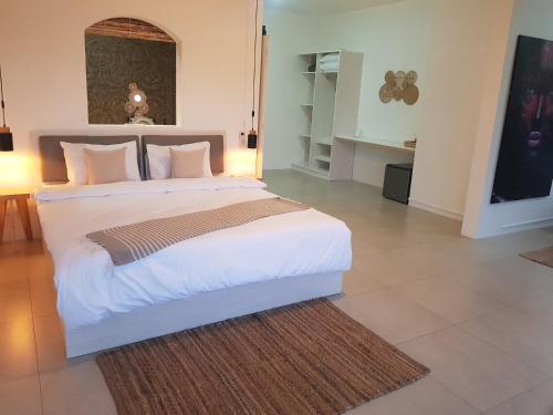 - une chambre dotée d'un grand lit avec des draps et des oreillers blancs dans l'établissement Villas Rocher - Deluxe Suite 2A, à Grand Baie