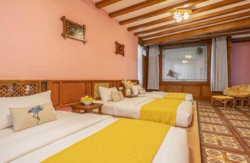 a bedroom with two beds with yellow and white at Frida's Inn 丽江梦之旅观景客栈 in Lijiang