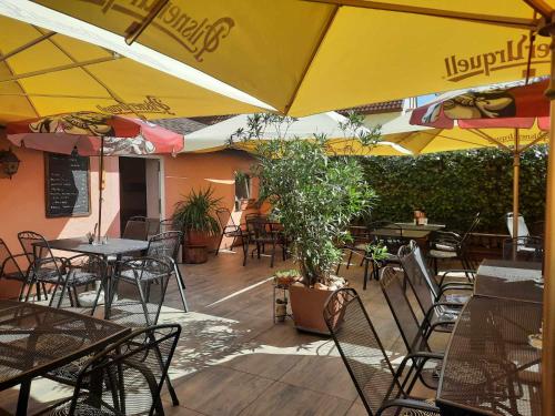 an outdoor restaurant with tables and chairs and umbrellas at Penzion Avena in Stříbro