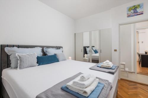 een slaapkamer met een groot wit bed en handdoeken bij Apartman Adriatic in Rijeka