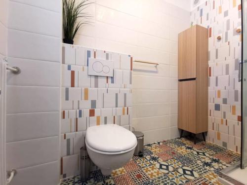 une salle de bain avec toilettes et un mur carrelé dans l'établissement Studio terrasse - 2 min de la mer, à Saint-Laurent-du-Var