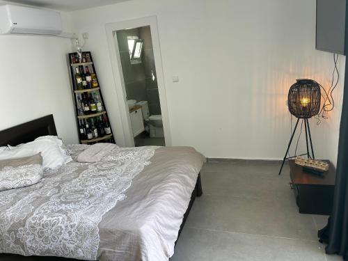 ein Schlafzimmer mit einem Bett und einem Tisch mit einer Lampe in der Unterkunft Shalva in Aschkelon