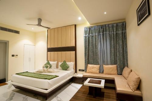 Un dormitorio con una cama y un sofá y una ventana. en PARK SIGNATURE HOTELS - Royal Benza, en Vijayawāda