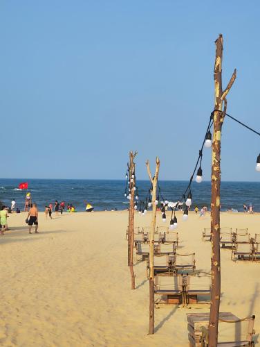 a beach with chairs and people on the beach at View Nhat Le Beach Hotel in Dong Hoi