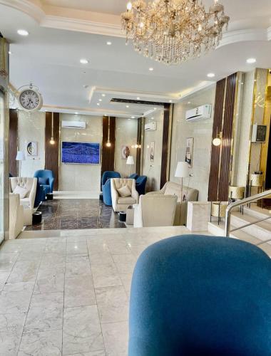 un vestíbulo con muebles azules y blancos y una lámpara de araña en خيال ابها للوحدات السكنية en Abha