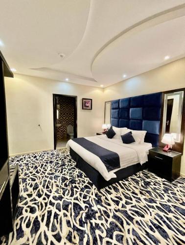 1 dormitorio grande con 1 cama grande y cabecero azul en خيال ابها للوحدات السكنية, en Abha