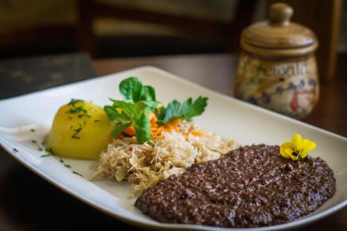 un plato de comida con arroz y verduras en una mesa en Pension & Biergarten Spreewaldhof Leipe, en Leipe