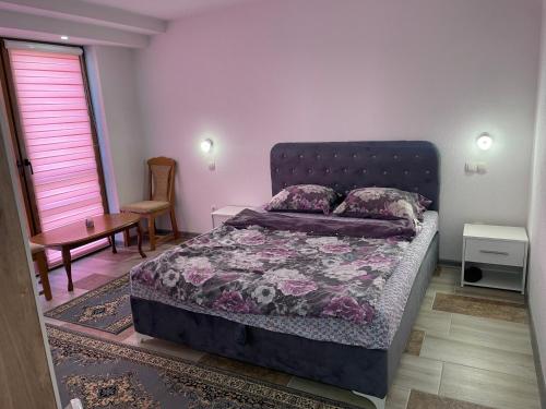 a bedroom with a bed and a table and a window at Exclusive apartments Visoko 2022 in Visoko
