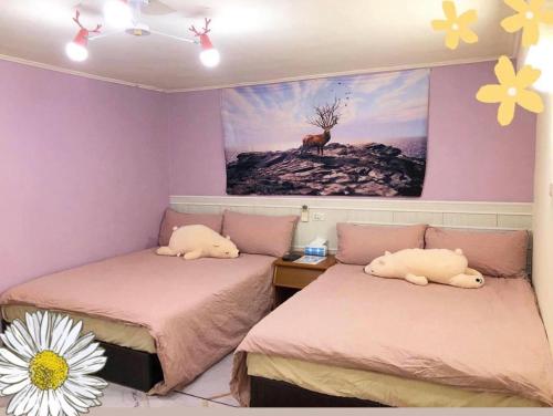 馬公市的住宿－風沙月民宿，墙上画画的房间里设有两张床