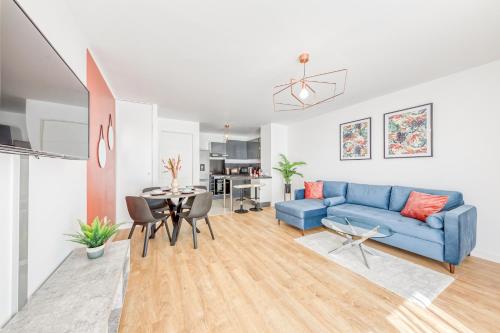 un salon avec un canapé bleu et une table dans l'établissement Massy Serenity - 64m2, Terrace, Balcony, Parking, à Massy