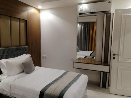 1 dormitorio con 1 cama grande y espejo en شقق درة العريش لشقق المخدومة, en Jazan