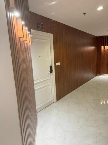 a hallway with a white door and wooden walls at شقق درة العريش لشقق المخدومة in Jazan