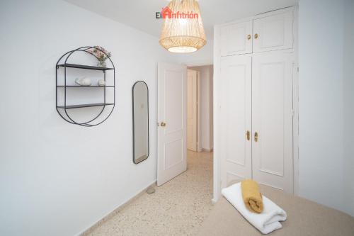 ein weißes Zimmer mit einem Spiegel und einem Bett in der Unterkunft El Anfitrión - Casa Dunas in Sanlúcar de Barrameda
