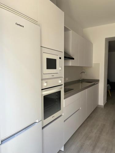 a kitchen with white cabinets and a microwave at Casa Pedro in Almodóvar del Río
