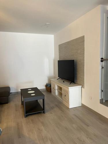 a living room with a flat screen tv and a table at Casa Pedro in Almodóvar del Río