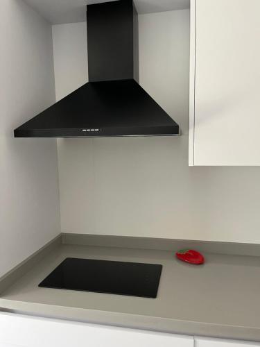 a stove top oven with a black hood in a kitchen at Casa Pedro in Almodóvar del Río