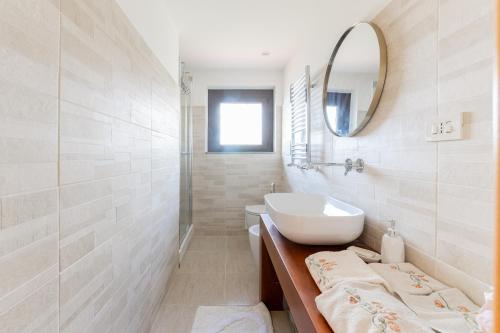 a white bathroom with a sink and a mirror at A casa di Fio' in Trevignano Romano