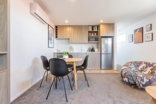 a kitchen and living room with a table and chairs at Luxury 1 Bed Apartment in CBD in Christchurch