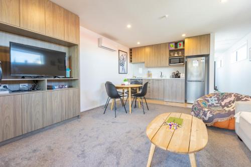 a living room with a bed a table and a kitchen at Luxury 1 Bed Apartment in CBD in Christchurch