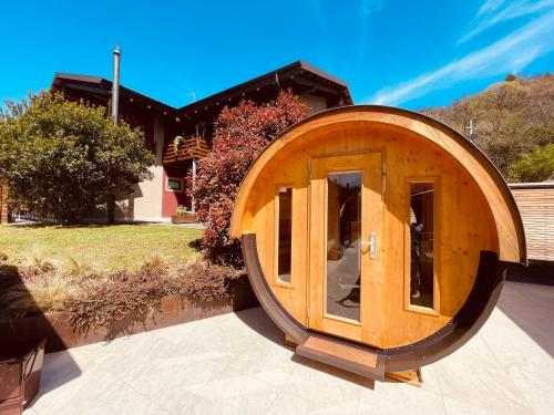 a large wooden circular building in front of a house at Agriturismo Il Cucchiaio di Legno in Orta San Giulio