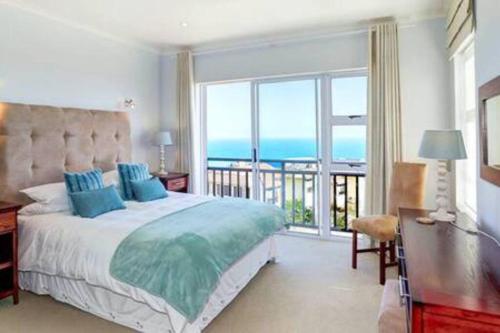 a bedroom with a bed and a view of the ocean at Luxury at Fynbos 5 in Mossel Bay