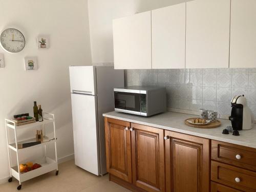 a kitchen with a microwave and a refrigerator at La Casa Gialla in Scardovari