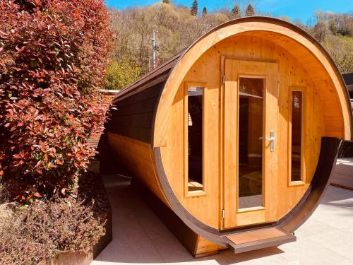 a wooden circular house with a door in a garden at Agriturismo Il Cucchiaio di Legno in Orta San Giulio