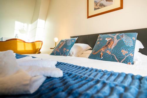 a bedroom with two beds with blue pillows at Château de Tilly in Boissey-le-Châtel