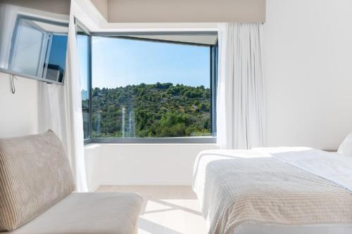 a bedroom with a bed and a large window at Villa Isola in Murter