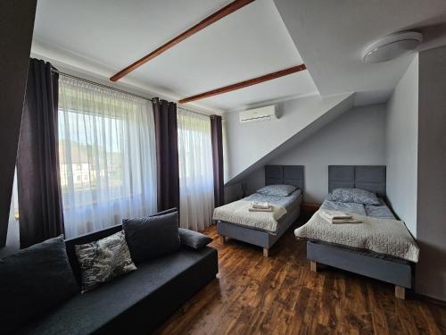 een woonkamer met 2 bedden en een bank bij Pensjonat POKUSA in Przewóz