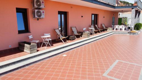 a swimming pool with chairs and tables on a house at Villa Leucatia in Sant’Agata Li Battiati 