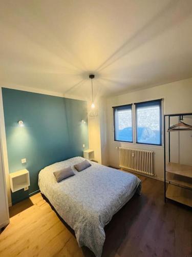une chambre avec un lit et deux fenêtres dans l'établissement Appart T4 85m2 spacieux climatisation parking, à Rodez