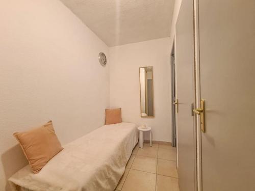 une petite chambre avec un lit et un miroir dans l'établissement Appartement 5 couchages + jardin à 150m des plages, à Saint-Raphaël