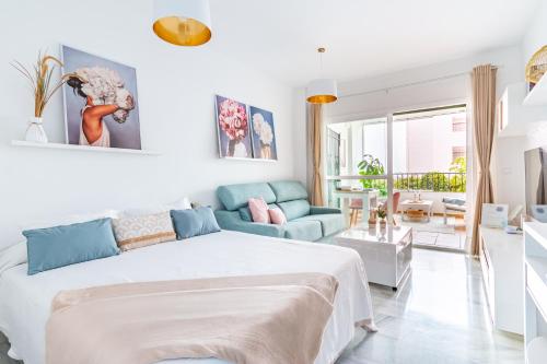 Un dormitorio blanco con una cama y un sofá. en Waiola Holiday, en La Cala de Mijas