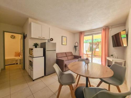 Il dispose d'une cuisine et d'un salon avec une table et un réfrigérateur. dans l'établissement Appartement 5 couchages + jardin à 150m des plages, à Saint-Raphaël