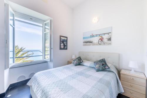 a white bedroom with a bed and a window at NEW 2024 Hanging Garden in Corniglia