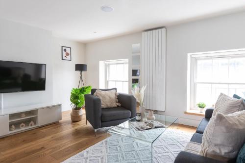 een woonkamer met een bank en een tv bij 2BR in Prime Soho & Fitzrovia - CityApartmentStay in Londen