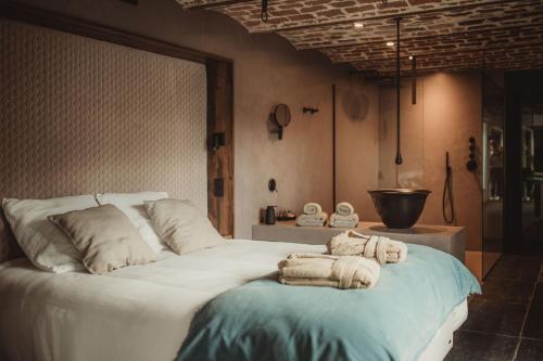 - une chambre avec un grand lit et des serviettes dans l'établissement L’exclusif, à Aubel