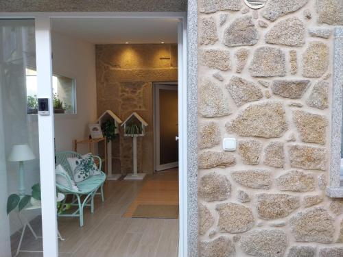 una camera con un muro di pietra accanto ad una porta di O berce casa rural camino Padrón Santiago a Padrón