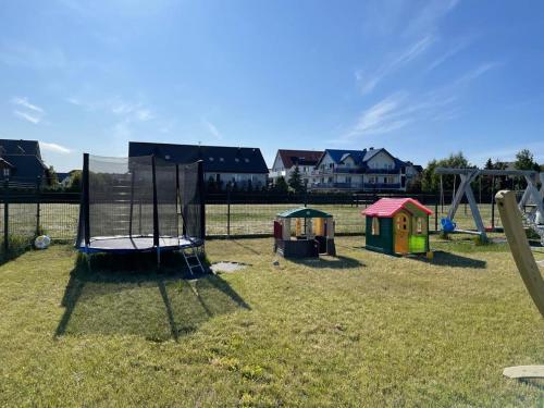 a playground with several play equipment in a field at Apartamenty Lagos in Karwia