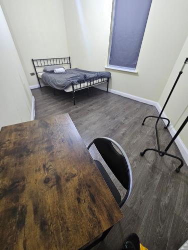 Habitación con mesa de madera y cama en Double room with Shared Bathroom (3), en Mánchester